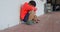 Side view of Asian schoolboy with head down sitting alone on the floor in corridor at school 4k