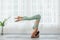 Side view of Asian woman doing Yoga exercise in front of windows,Yoga HandStand pose or Pincha Mayurasana,Calm of healthy young