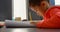 Side view of attentive Asian schoolboy studying at desk in classroom at school 4k
