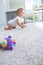 Side view of a baby crawling on carpet