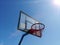 Side view of basketball ring basket outdoor with clear blue sky on background and bright sun at corner with flares and sunbeams