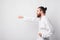 Side view of bearded man wearing taekwondo uniform punching over white background