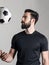 Side view of bearded young football or soccer player throwing ball