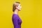 Side view of beautiful serious woman showing her neck with clean young skin.  on yellow background