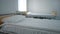 Side view beds in hospital ward with white clean bedding. Cozy room in medical clinic indoors with no people. Concept of