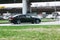 Side view of black BMW 520D car riding on the road on high speed. Shiny black sedan car in motion. Urban scene with riding vehicle