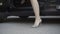 Side view of black car door open and unrecognizable slim Caucasian woman walking away on high-heels. Stylish confident