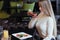 Side view. Blonde girl taking picture of vegetable salad in the restaurant