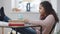 Side view of bored disinterested African American teen student yawning sitting with feet on table ignoring online lesson