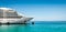 Side view and bow of a docked cruise ship on a summer day with clear blue sky