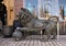 Side view of a bronze lion on mosaic covered sidewalk  in front of a store in Marrakesh, Morocco.