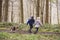 Side view of brother and sister walking pet dog in a wood