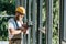 side view of builder in hardhat and protective googles installing windows by drill