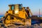 Side view of a bulldozer with a scoop on the beach, ground moving machine, groundwork industry equipment