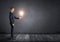 Side view of businessman standing and holding glowing light bulb in his hand