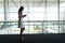 Side view of businesswoman using mobile phone in office and walking on a carpet walkway