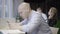 Side view of busy concentrated man surfing Internet on smartphone in office. Portrait of focused young Caucasian bald