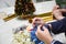 Side view Busy Woman s hands wrapping christmas gift, close up, unprepared chistmas presents on cement table at indoors home park