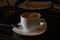 Side view of cappuccino cup on table in dark cafe room