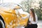 Side view of caucasian businesswoman on white shirt and pants using sponge for cleaning car door