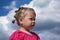 Side view of caucasian child of two years looking aside with serious look with interest on the blue sky
