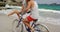 Side view of Caucasian couple riding a bicycle on the beach 4k