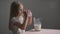 Side view Caucasian little girl drinks milk from a glass,