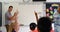 Side view of Caucasian male teacher teaching schoolkids on whiteboard in the classroom 4k