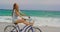 Side view of Caucasian woman riding a bicycle on the beach 4k