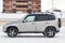 Side view of a Chevrolet Niva, a Russian-American car in the snow in winter