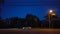 Side View of City Road Traffic Driving at Night.  City Life Urban Landscape With Street Light at Dusk.