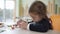 Side view close-up of concentrated schoolgirl modelling clay at desk in school on arts lesson. Focused beautiful