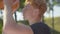 Side view close-up of redhead basketball player throwing ball in hoop outdoors. Portrait of Caucasian sportsman training