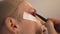 Side view close-up travesty man applying eyeshadow in slow motion. Confident proud Caucasian LGBT person doing makeup