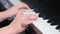 Side view of closeup Asia boy playing piano at home. Used ten fingers to press piano key