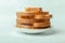 Side view closeup of slices of loaf bread carefully stacked on a plate like a small tower