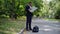 Side view of concentrated African American man in suit examining paper map outdoors with travel bag on sidewalk. Wide