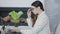 Side view of concentrated young slim woman typing on laptop keyboard and taking off eyeglasses having migraine. Portrait