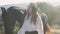 Side view of confident horsewoman in straw hat and graceful animal walking in sunrays in summer mountains and leaving