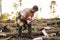 Side view on confident lumberman collecting prepared chopped firewood in forest