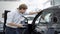 Side view of confident man looking in car salon in dealership or showroom. Young Caucasian male buyer choosing new