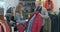 Side view of confident positive couple examining red coat in clothing shop. Caucasian man and woman choosing winter