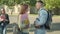 Side view of confident young man asking out redhead woman on campus yard. Portrait of loving Caucasian students talking