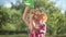 Side view curios redhead little boy with paper plane standing in sunshine outdoors looking away. Curly-haired cute