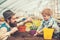 Side view daddy looking at his lovely boy playing with soil. Hipster with stylish beard in fedora hat helping his son