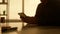 Side view dark silhouette of a man is talking on a video call using a digital tablet. A male manager, designer or