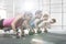 Side view of determined people doing pushups with kettlebells at crossfit gym