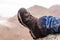 Side view of a dirty hiking shoe with mountains in the background