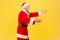 Side view of egoistic elderly man with gray beard wearing santa claus costume standing with raised arms, being ready to hug,