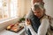 Side view of an elderly couple hugging each other at home. Senior woman embracing her husband with closed eyes standing in kitchen